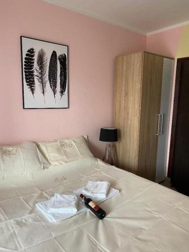 a white bed with a bottle of beer on it at Apartman Snezana Kalimanj in Tivat