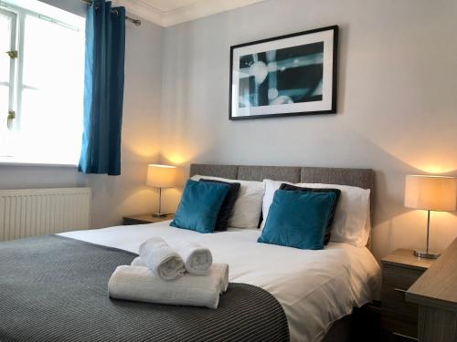 a bedroom with a bed with towels on it at Delight Marvel - Cades Place in Maidstone