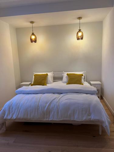 a bedroom with a large white bed with yellow pillows at SeaViewApartment in Swanage