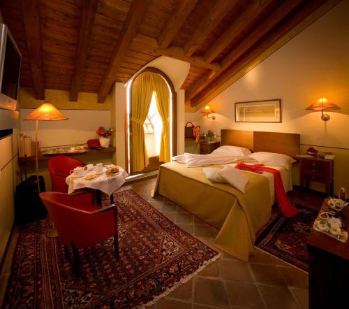 1 Schlafzimmer mit 2 Betten, einem Tisch und einem Spiegel in der Unterkunft Albergo dell'Agenzia in Bra