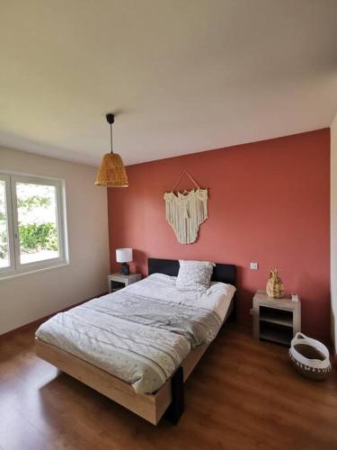 - une chambre dotée d'un lit avec un mur rouge dans l'établissement Calme entre pins et océan, à Onesse-et-Laharie