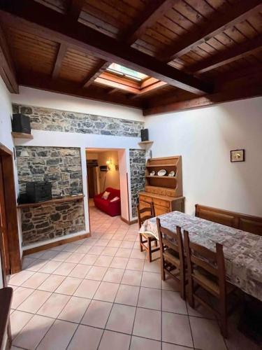 a dining room with a table and a stone fireplace at Appartamento Rita in Asso