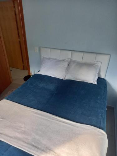 a large bed with blue sheets and white pillows at Cantin da Mata in Domingos Martins