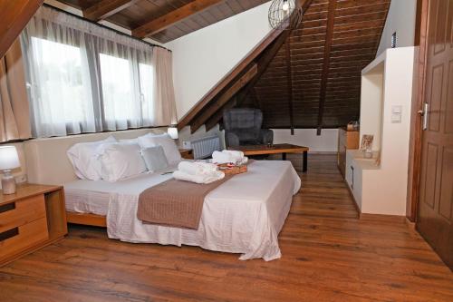 1 dormitorio con 1 cama con sábanas y almohadas blancas en Villa Alex en Agios Georgios