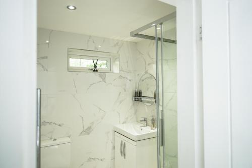a white bathroom with a sink and a shower at SLS VACATION STAY in Kent