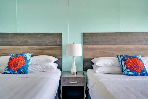two beds sitting next to each other in a bedroom at Admiral's Quarters in Kure Beach