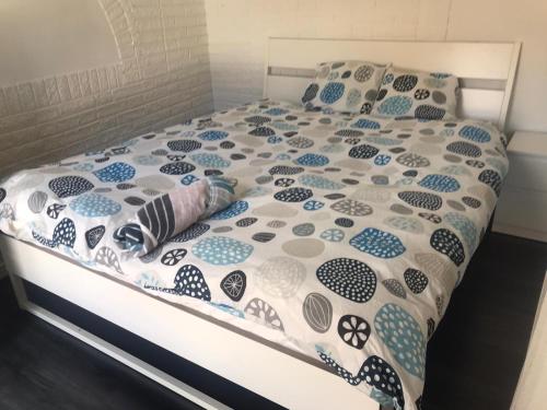 un letto con piumino e cuscini blu e bianchi di Nice Entire Semi - Attached House - M a Umeå