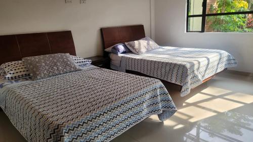 Cette chambre comprend 2 lits et une fenêtre. dans l'établissement Casa Quinta con Billar, Tejo, Jacuzzy climatizado, kiosco, piscina, à La Vega