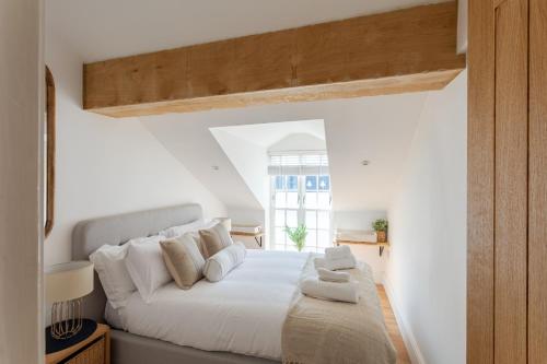 a white bedroom with a large bed with white pillows at Boutique Old Sea Stable - 1 minute from beach in Tynemouth