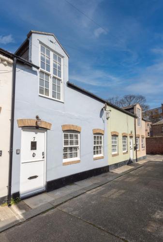 a white building with windows on a street at Boutique Old Sea Stable - 1 minute from beach in Tynemouth