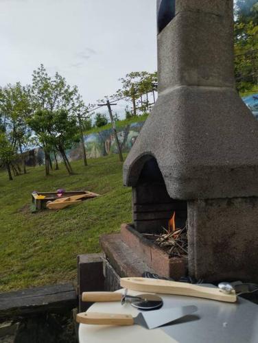 a stone oven with two surfboards on top of it at Mini hiška v objemu vinograda in Pristava pri Mestinju