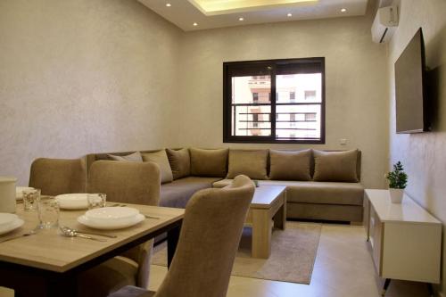 ein Wohnzimmer mit einem Sofa und einem Tisch in der Unterkunft Magnifique appartement Marrakech in Marrakesch