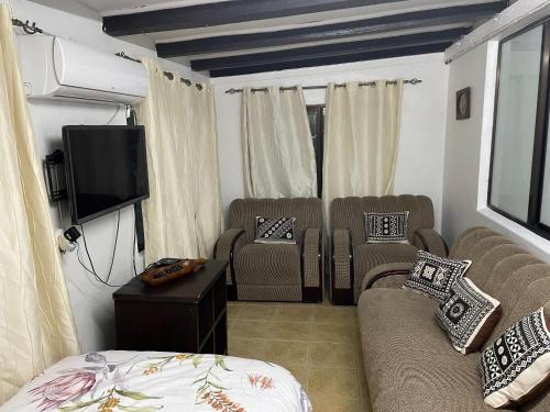 ein Wohnzimmer mit Sofas und einem Flachbild-TV in der Unterkunft Marys Cottage 