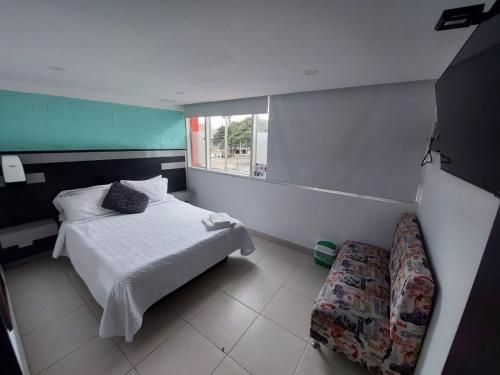 a small bedroom with a bed and a window at Hotel Boutique San Sebastián Chapinero in Bogotá