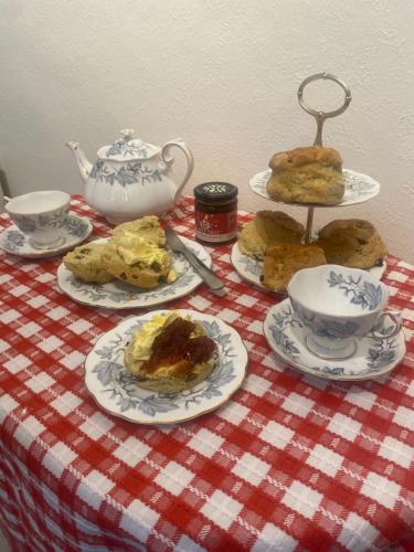 a table topped with plates of food and tea sets at Peaceful Coastal Apartment in Ventnor