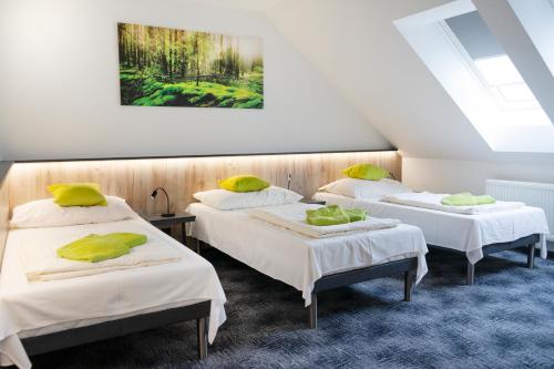 two beds in a room with a painting on the wall at Penzion Smile in Brno