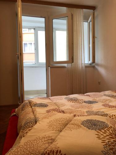 a bedroom with a bed and two windows at Apartman Ilidža Pejton in Sarajevo