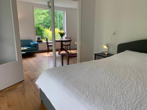 a bedroom with a white bed and a living room at Loveland in Bergen