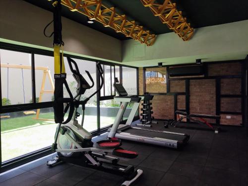 a gym with two tread machines in a room with windows at El Sol by Wynwood House in Lima