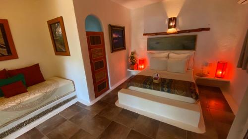 a room with two beds with red lights in it at Bambuddha Centro Holistico in Barra Vieja