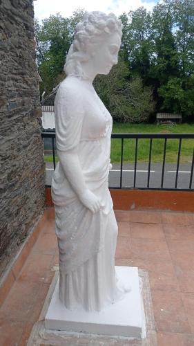 a statue of a woman standing on a sidewalk at LA GALLEGA in Valdoviño