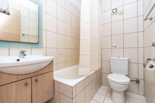 a bathroom with a toilet and a sink and a mirror at Flora Hotel Apartments in Protaras