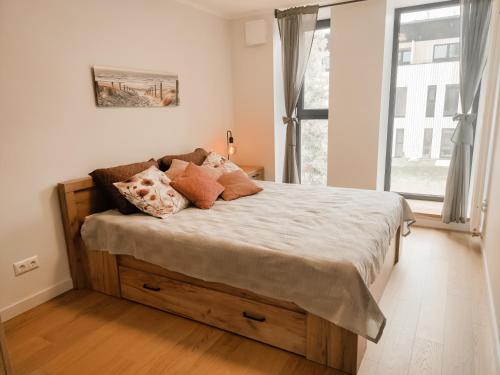 - un lit avec des oreillers dans une chambre avec une fenêtre dans l'établissement Beautiful Seaside apartement Albatross 24, à Ķesterciems