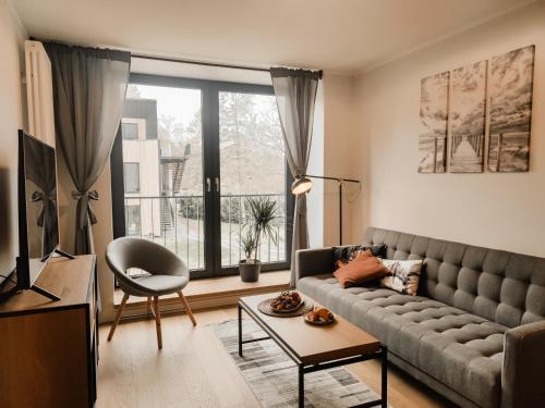 - un salon avec un canapé et une grande fenêtre dans l'établissement Beautiful Seaside apartement Albatross 24, à Ķesterciems