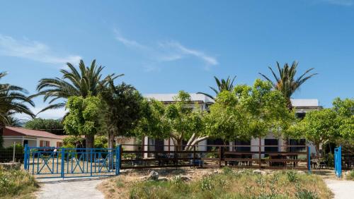 un edificio con palmeras y parque infantil en Milos studios & Beach House, en Frangokastello