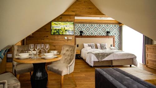 a bedroom with a bed and a table and chairs at Aparthotel Merynos in Zakopane