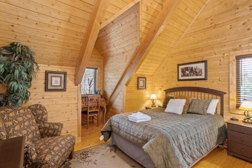 a bedroom in a log cabin with a bed and a chair at Fire And Ice in Blowing Rock