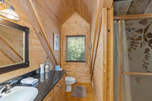 a bathroom with a sink and a shower in a log cabin at Fire And Ice in Blowing Rock