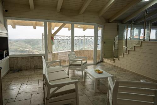 a screened in porch with chairs and a table at וילה לין בחרמון in Majdal Shams