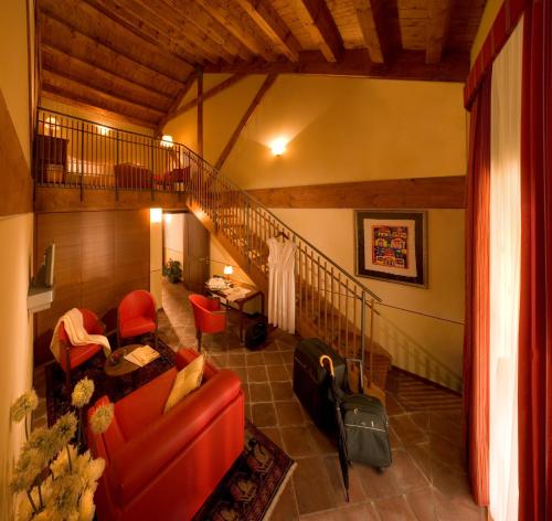 a living room with red chairs and a staircase at Albergo dell'Agenzia in Bra