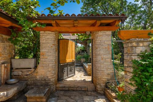 a stone patio with an outdoor kitchen in a garden at Holiday Home Eufemia in Svetvinčenat