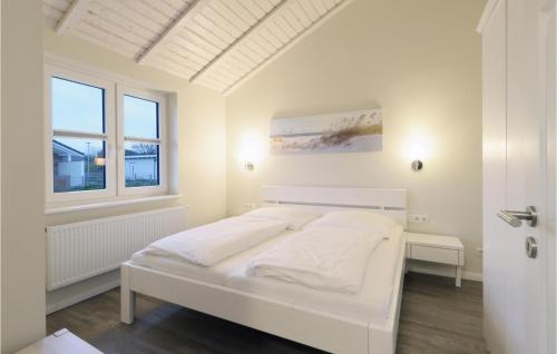 ein weißes Schlafzimmer mit einem Bett und einem Fenster in der Unterkunft Beautiful Home In Dagebll With Wifi in Dagebüll