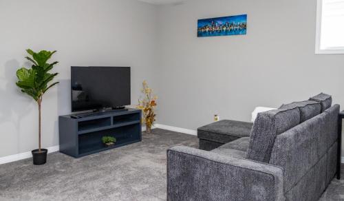 a living room with two chairs and a flat screen tv at The Jade Place in Airdrie