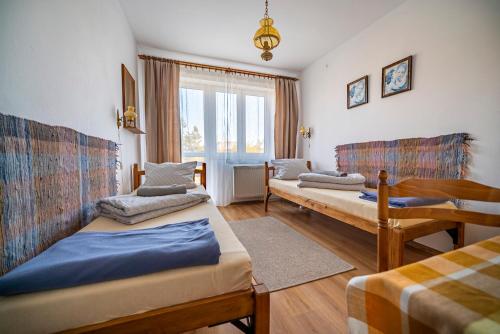 ヤストシェンビャ・グラにあるArka Przystańのベッド2台と窓が備わる客室です。