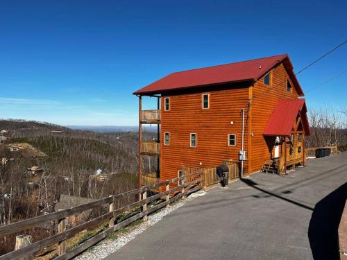 a wooden barn with a red roof on the side of a road at * 3 Master BR, Views, Theater, Arcade, Pinball in Gatlinburg