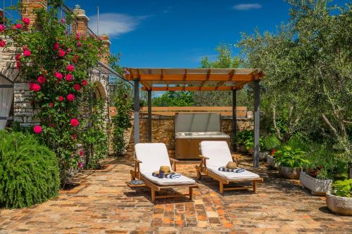 a patio with two chairs and a grill in a garden at Holiday Home Eufemia in Svetvinčenat