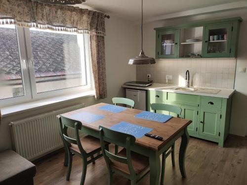 a kitchen with a wooden table and chairs and a sink at apartman šumiac 5 in Šumiac