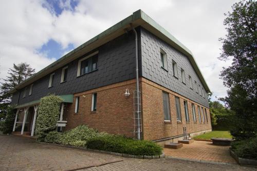 a large brick building with a black roof at Apartment/Unterkunft mit Küche in guter Lage in Nettelsee