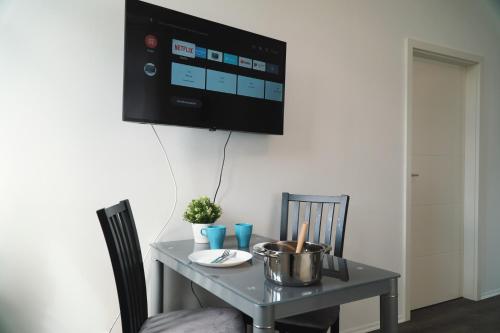 a dining room table with a tv on the wall at Apartment/Unterkunft mit Küche in guter Lage in Nettelsee