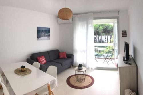 ein Wohnzimmer mit einem Sofa und einem Tisch in der Unterkunft T2 très agréable et proche de la mer in La Grande-Motte