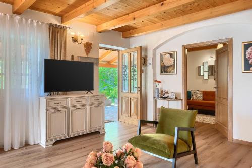 a living room with a television and a green chair at Holiday Home Eufemia in Svetvinčenat