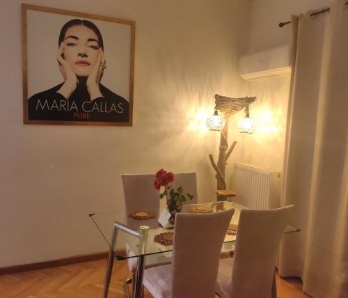a dining room with a table and a picture of a woman at Athens Riviera apt with seaview, 15' to Acropolis in Athens