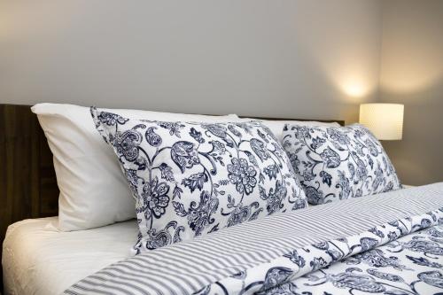 Cama con sábanas y almohadas azules y blancas en The Jade Place en Airdrie