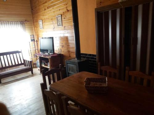 a dining room with a table and a television at La Peninsula Cabaña in San Carlos de Bariloche