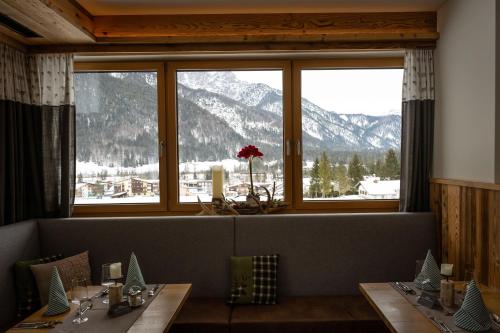 a dining room with a view of a mountain at Hotel Landhaus Tirolerherz in Sankt Ulrich am Pillersee