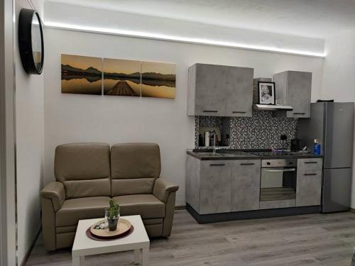Il comprend un salon avec un canapé et une cuisine. dans l'établissement MELIREB APPARTAMENT ELEGANCE, à Turin